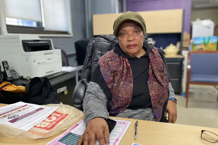 Darlene Waters, the Chelsea-Elliott Houses Tenant Association President, sits behind her desk that contains piles of annoucements.